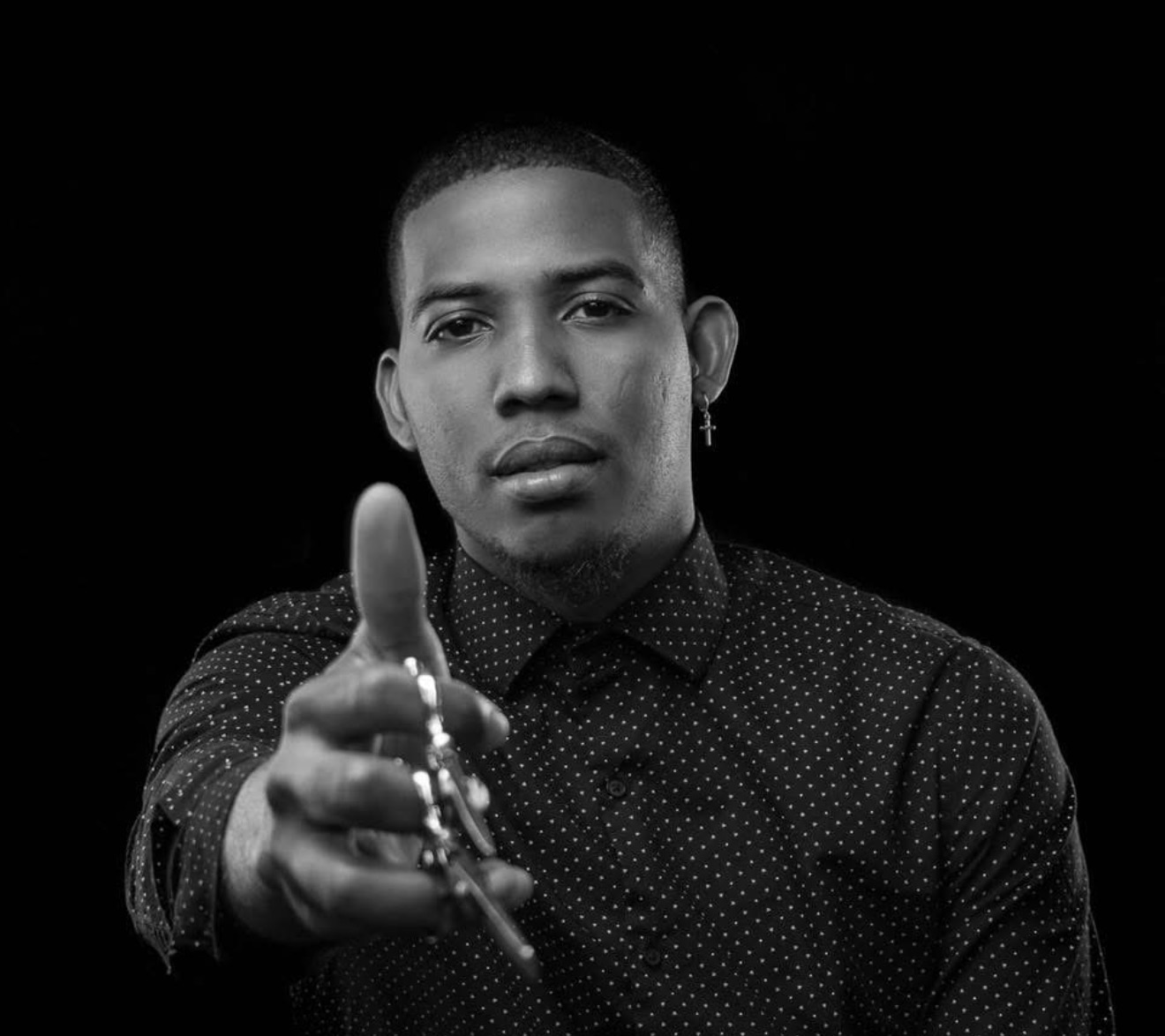 Jeffrie, JPB Studio's barber and owner, offering a pair of shears to the camera