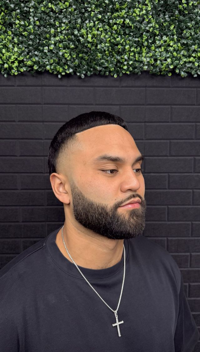 Skin fade blended into a full sculpted beard, side profile
