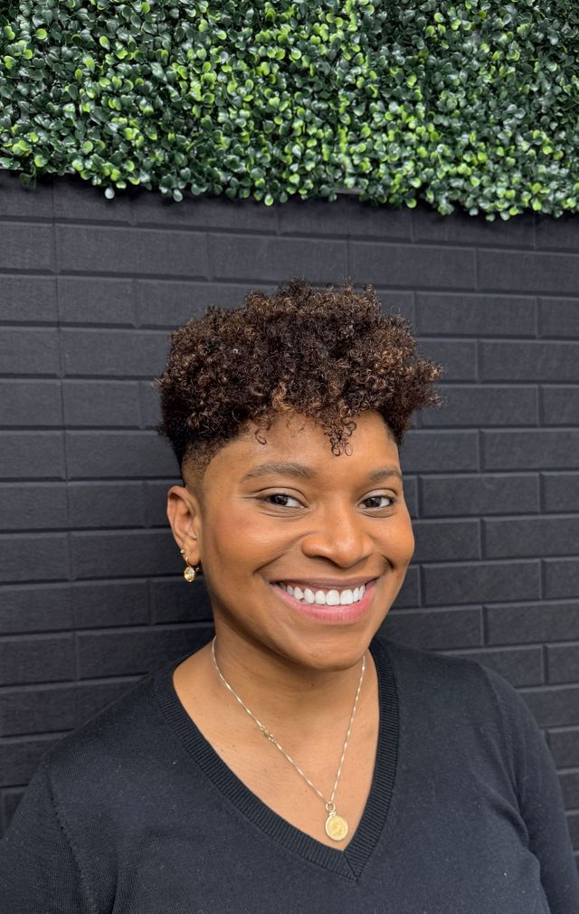Tapered natural curls cut and shaped, client smiling
